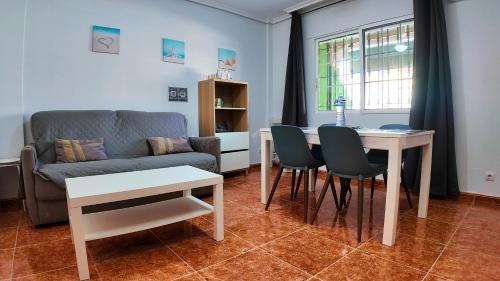 a living room with a couch and a table and chairs at Apartalux Vista Mar in La Manga del Mar Menor