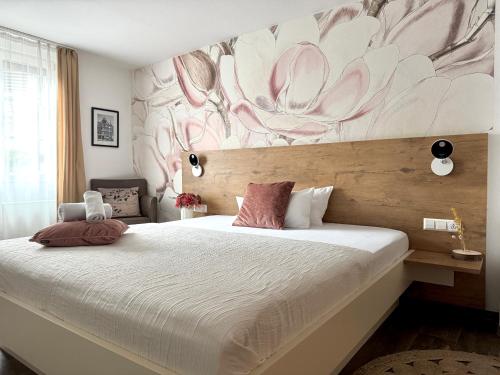 a bedroom with a large bed with a flower mural on the wall at Adler Hotel und Restaurant Schiltach in Schiltach