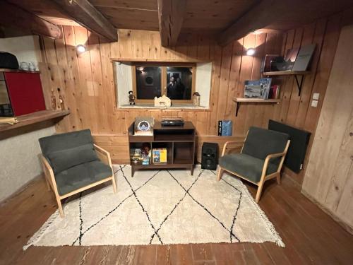 a living room with two chairs and a television at La grange du Taillat in Campan