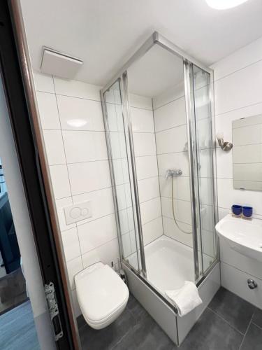 a bathroom with a shower and a toilet and a sink at FlyInn-Pension Airport-Messe in Leinfelden-Echterdingen