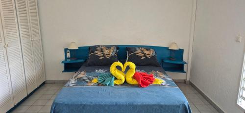 a blue bed with two rubber swans on it at TOUMALACAÏ Appart 245 in Folle Anse
