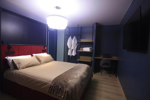 a bedroom with a bed and a desk with a television at Casa dos Americanos - Suite Wellness in Briño