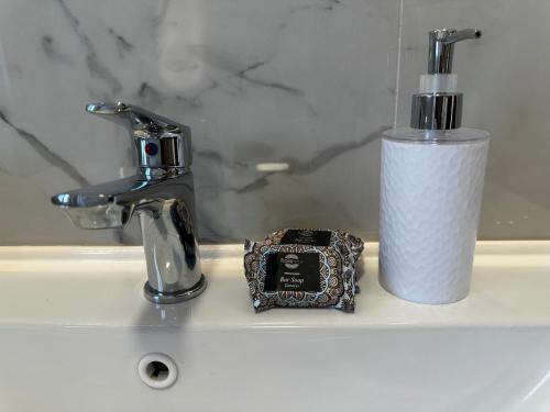 a bathroom sink with a faucet and a roll of paper towels at Modern Getaway Meets Nature in Ishull-Shëngjini
