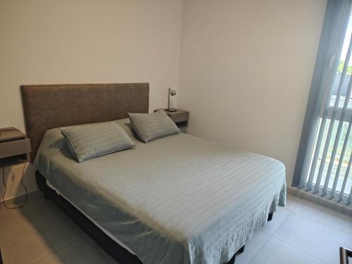 a bedroom with a bed with two pillows on it at Arévalo - D2 in Cipolletti