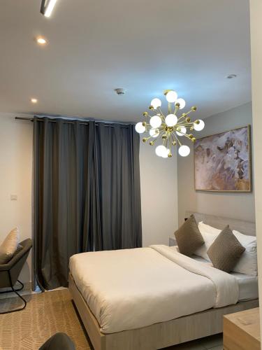 a bedroom with a large bed and a chandelier at Embassy Gardens in Accra