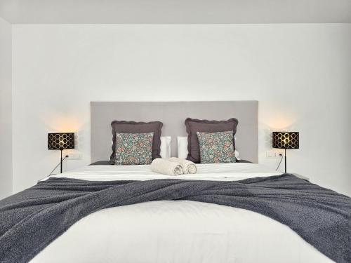 a large white bed with two pillows and two lamps at AUX VILLAS DE MICK in Callao Salvaje