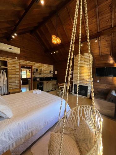 a bedroom with a swinging bed in a room at Chalé Miragem dos Canyons in Praia Grande