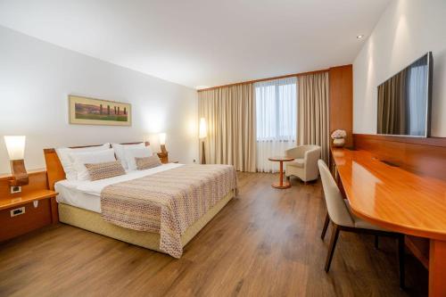 a hotel room with a bed and a desk at Perla, Resort & Entertainment in Nova Gorica