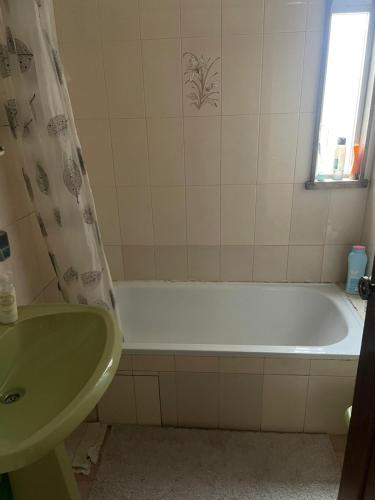 a bathroom with a bath tub and a sink at Daboussi Home in Apúlia