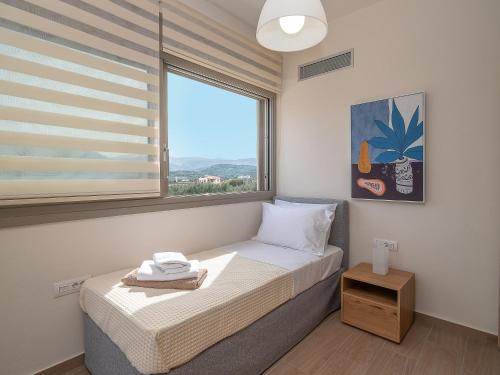 a small bedroom with a bed and a window at Utopia Luxury Villas in Gouves