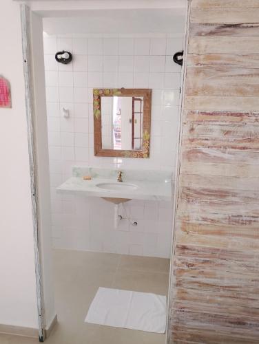 a bathroom with a sink and a mirror at Vila Luiza Ubatuba in Ubatuba