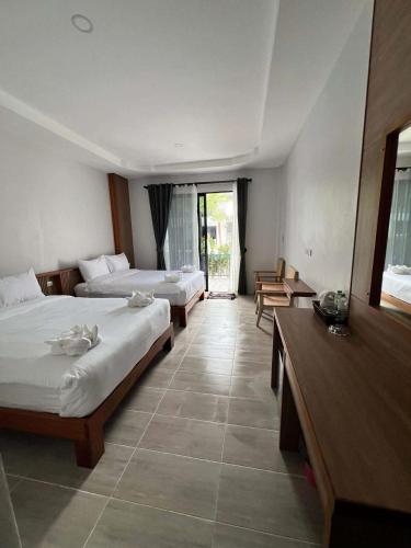 a hotel room with two beds and a balcony at Double Rock Beach Hotel in Thong Sala