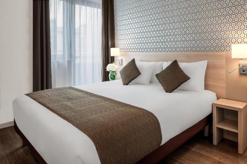a bedroom with a large white bed with a window at Citadines Bastille Gare de Lyon Paris in Paris