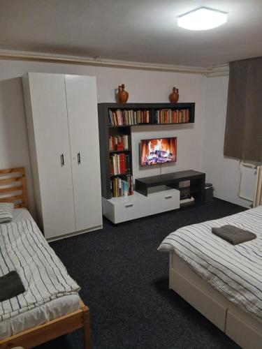 a bedroom with two beds and a tv on a shelf at Smart hostel in Belgrade