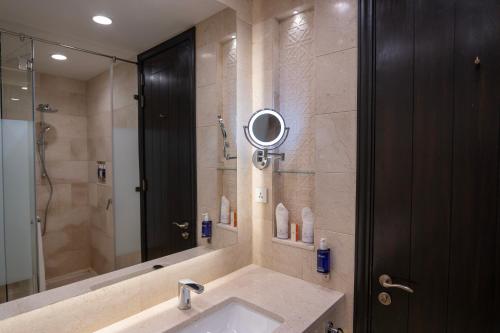 a bathroom with a sink and a shower with a mirror at Sost Serena Hotel in Gircha