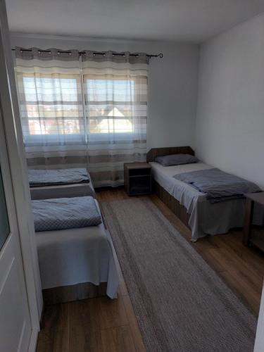 a bedroom with two beds and a window at Sári Vendégház in Remetea