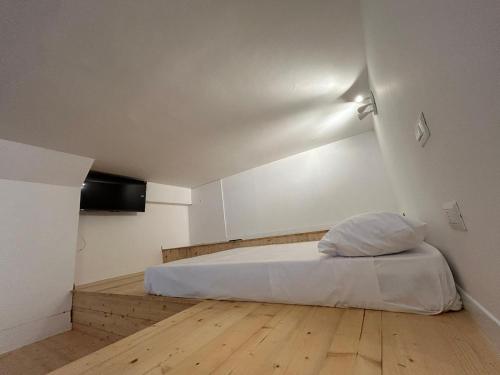 a bedroom with a white bed and a wooden floor at Loft bridge in Ascoli Piceno
