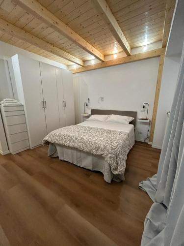 a bedroom with a bed and a wooden ceiling at Loft bridge in Ascoli Piceno