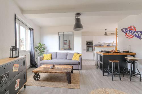 a living room with a couch and a table at Appart lumineux, WIFI haut débit, proche gare 7 min, Lyon 15 min in Couzon-au-Mont-dʼOr