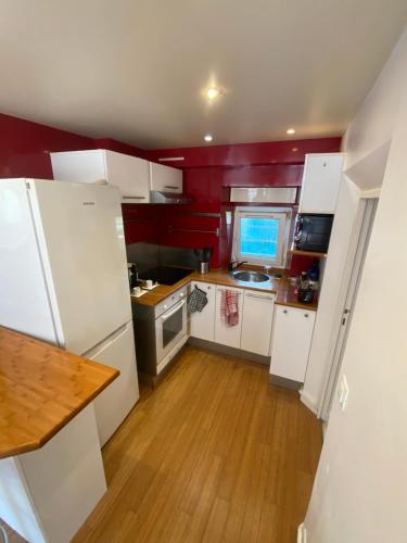 a small kitchen with white appliances and a wooden floor at studio confort seine port in Seine-Port