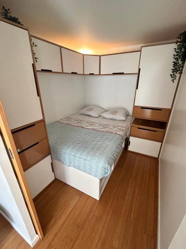 a small bedroom with a bed and white cabinets at studio confort seine port in Seine-Port