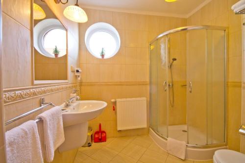 a bathroom with a shower and a sink and a shower at Villa Tropikana in Łeba