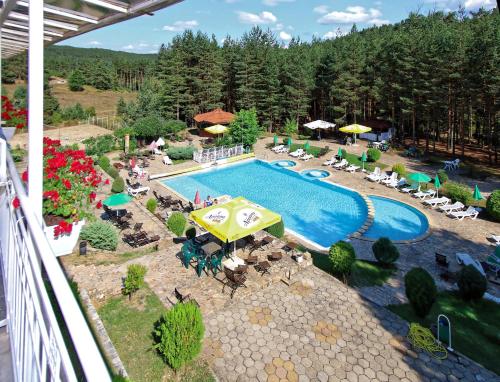 an overhead view of a swimming pool with chairs and umbrellas at Hotel Zora in Velingrad