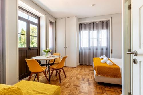 a room with a bed and a table and chairs at Magnolia Inn in Aveiro
