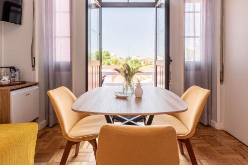 a dining room with a table and chairs and a window at Magnolia Inn in Aveiro