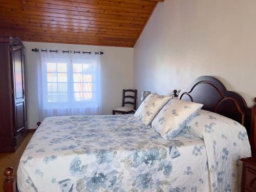 a bedroom with a bed and a window at A Casa do Navio in Capelas