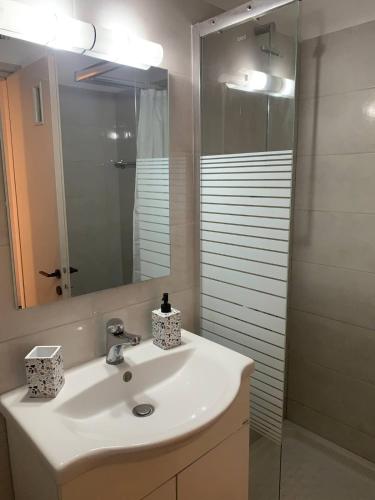 a bathroom with a white sink and a mirror at Athina Central Corfu Town Apartment in Ágios Rókkos