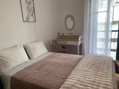 a bedroom with a bed and a desk and a mirror at Athina Central Corfu Town Apartment in Ágios Rókkos