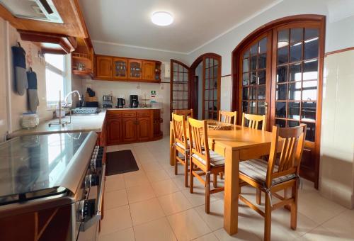 a kitchen with a wooden table and chairs at A Casa do Navio in Capelas