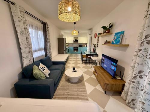 a living room with a blue couch and a tv at Olivia One Bedroom Apt renovated 2026 in Paralimni