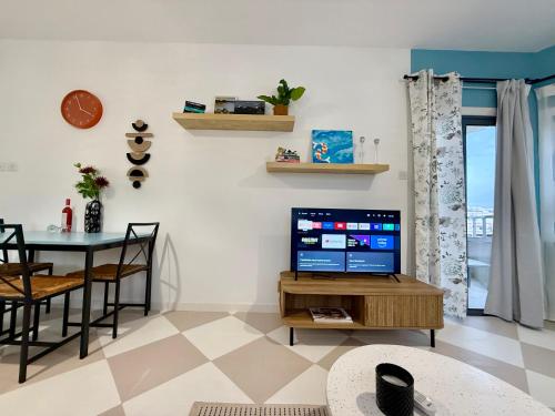 a living room with a television and a table at Olivia One Bedroom Apt renovated 2026 in Paralimni
