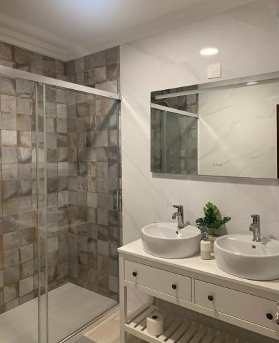 a bathroom with two sinks and a shower at Casa Sardine in Santo Isidoro