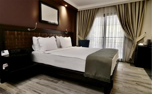 une chambre d'hôtel avec un grand lit et une fenêtre dans l'établissement Resa Hotel Göcek, à Göcek