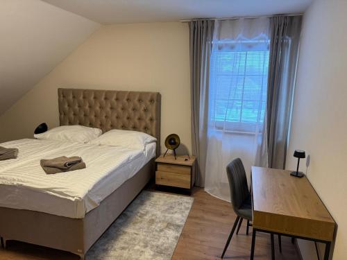 a bedroom with a bed and a desk and a window at Pensione Ristorante Moretti in Nitra