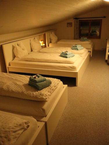 two beds in a hotel room with towels on them at Ski- und Berghaus Obergmeind in Tschappina