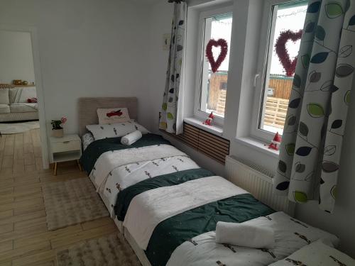 two beds in a room with two windows at Biela Magnólia in Vrbov