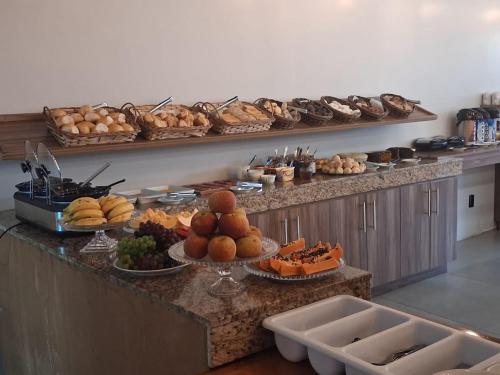 a buffet with many different types of food on a counter at Hotel Ponto 1 in Vacaria