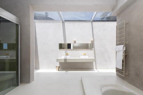 a bathroom with a sink and a large window at Luxury 8-Suite Villa with Heated Pools, Ocean & Mountain Views in Cape Town