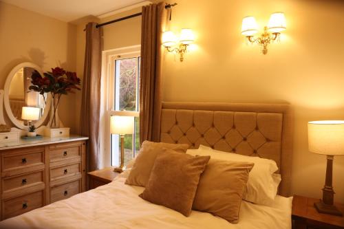 a bedroom with a bed and a mirror and a window at Cuilcagh Luxury Studio in Enniskillen