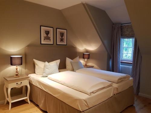 a bedroom with two beds and two lamps at Gut Altholz Landhotel und Restaurant Hutter in Plattling