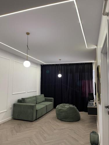 a living room with a green couch and a ottoman at Apartament 2 camere Fial in Bacău