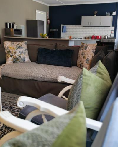 a living room with a brown couch and pillows at Summerville Place in Addo