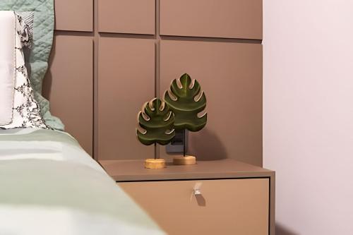 two cactus plants on a nightstand next to a bed at Modernidade no Coração de Cuiabá in Cuiabá
