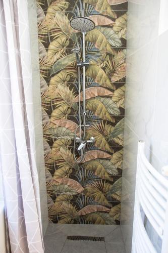a bathroom with a shower with a tropical wallpaper at BB Apartman Hajdúnánás in Hajdúnánás