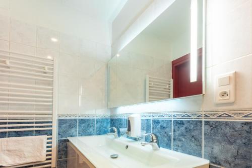 a bathroom with a sink and a mirror at Hôtel d'Ossau in Laruns