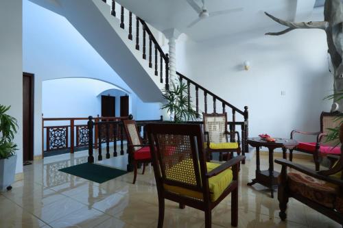 ein Wohnzimmer mit Stühlen und einer Treppe in der Unterkunft Flamingo Guest house in Unawatuna